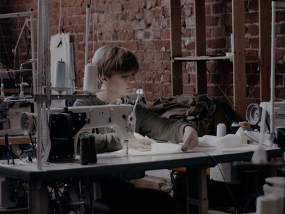 In a bright and ethical factory, skilled artisans bring sustainable fashion to life, sewing garments that embody care for both people and the planet