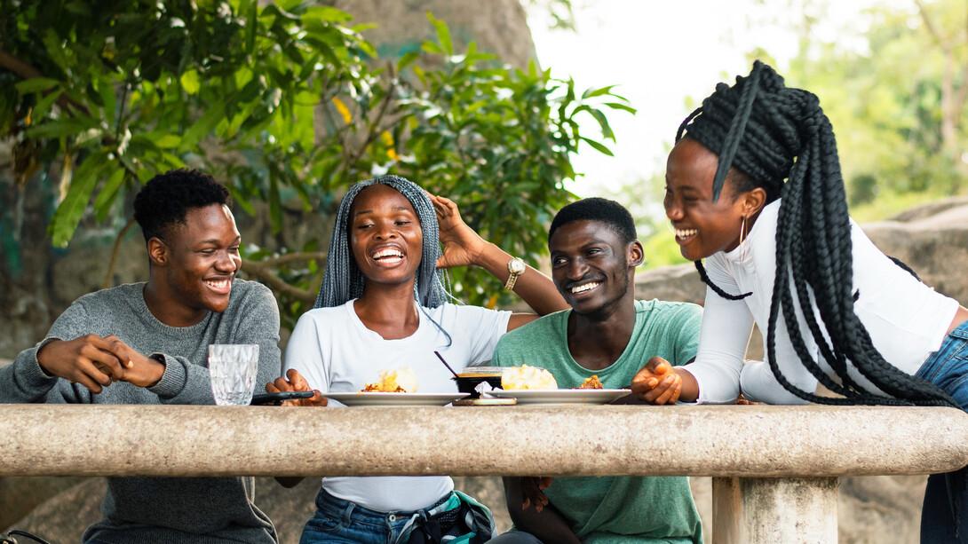 Friends share stories and smiles as they dig into a hearty meal of fufu, turning a simple gathering into a celebration of culture and connection