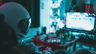 A gamer playing a video game in a dark room while wearing a gaming helmet