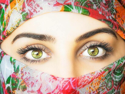 A woman who clearly underwent the Keratopigmentation procedure and now has light eyes of a yellowish hue