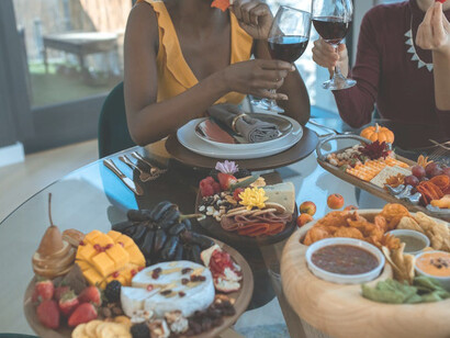 Two women indulge in wine and cheese at a beautifully presented wine table