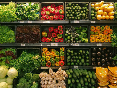 In a supermarket grocery store in the USA, you'll find a fruit display featuring yellow and red apples meticulously arranged on a black plastic crate