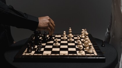 Dettaglio di una mano che valuta la prossima mossa sulla scacchiera