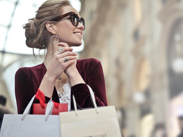 A woman holding shopping bags, reflecting the luxury lifestyle often associated with influencers