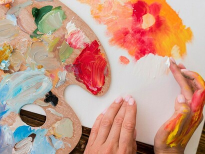 A top view of an artist using their hands to paint with colors, capturing the creative process