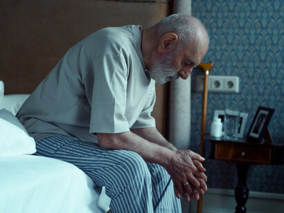 Elderly man staring at the ground, lifeless, meaningless