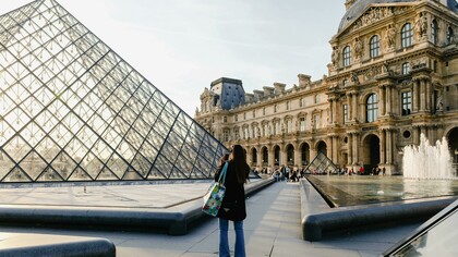 A woman photographs a building in Paris, Île-de-France, France