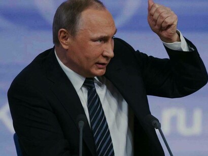Russian President Vladimir Putin with a fist raised is numerating the progress that Russia had made over the last few years on national television