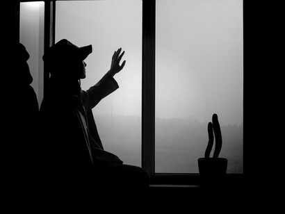 Silhouette of a person standing by a window