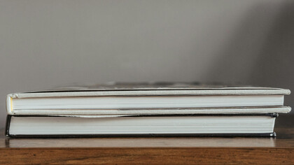 Dicionários visuais sob mesa de estudos de uma professora de linguagem