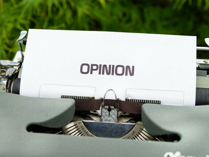 Una máquina de escribir con una hoja en la que se lee la palabra opinión