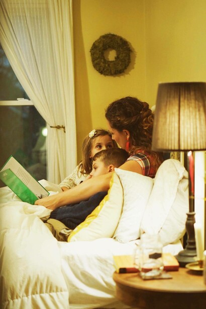 Bimbi e mamma che leggono un libro: “leggere libri illustrati ai bambini stimola il loro linguaggio e la loro immaginazione, mentre raccontare storie o cantare filastrocche favorisce il legame genitore-figlio”