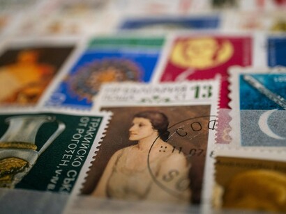A close-up shot of Soviet-era stamps on a table, showcasing a collection of childhood memorabilia from the Soviet Union
