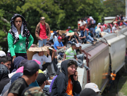 Central American immigrants ride north atop a freight train known as "La Bestia"