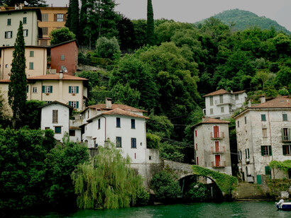 A picturesque hillside village overlooking Lake Como in Lombardy, Italy, glowing under the summer sun