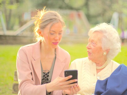 FIlha mostra algo em seu celular à mãe