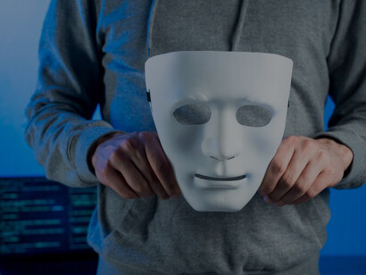 A person holding a mask to conceal their identity online, symbolizing anonymity on the internet