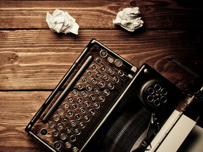Papeles arrugados junto a una máquina de escribir