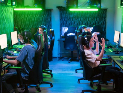 A scene of people playing computer games in a 2000s-era internet café