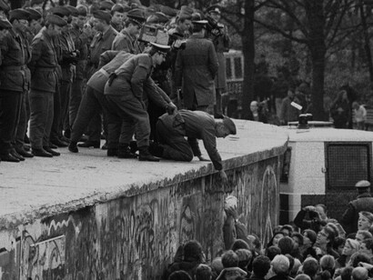 Jubilant Berliners tearing down the Berlin Wall capture the emotional moment when decades of division between East and West Germany finally ended, symbolising the reunification of a nation