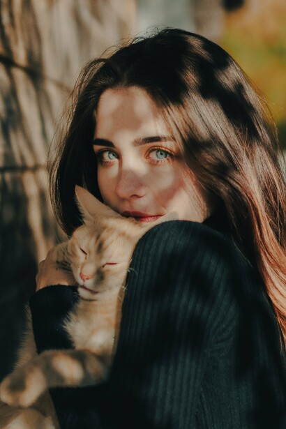 Mulher interage de perto com um gato, em uma cena que evidencia a relação de proximidade entre pessoa e animal. A imagem ajuda a visualizar o sentido literal de “gata”, antes que o texto explore sua transformação em uma expressão de sentido figurado