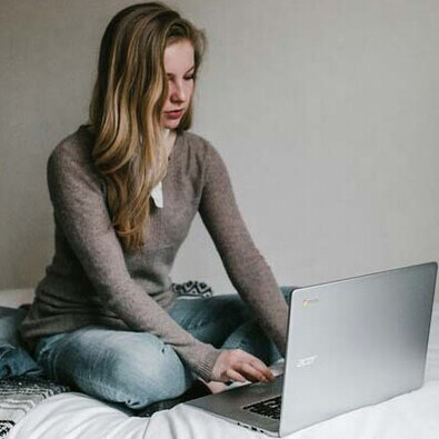 A woman working on her laptop at night; using  laptops and phones at night can trigger adverse physical and psychological responses