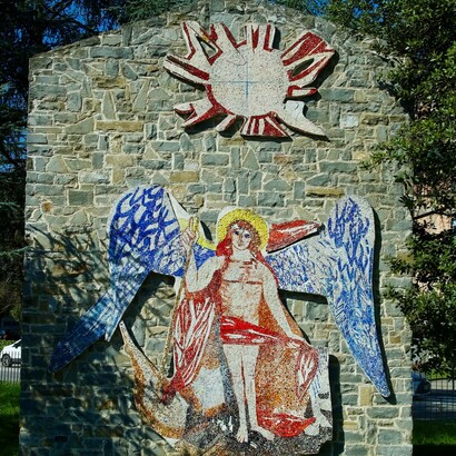 "San Michele Arcangelo" raffigura San Michele sovrastato dal sole, simbolo della luce divina; ai suoi piedi potete notare zone di colore rosso e nero, a simboleggiare il demonio. San Michele è l'angelo guerriero che sconfigge il male. L'opera è stata eseguita da Bruno Saetti, nato a Bologna nel 1902 e scomparso nel 1984 (anno di realizzazione dell'opera)
