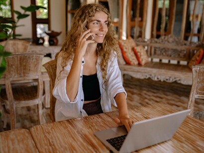 A millennial working remotely and is glad to be on the phone with their superior 