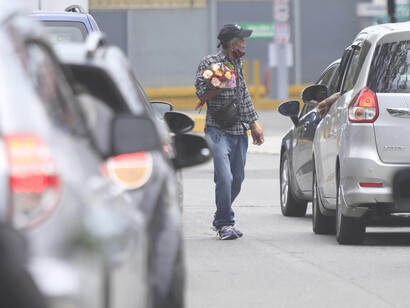 Empleo informal en Costa Rica: un adulto mayor vende flores en una calle