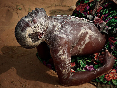 Un ballerino Voodoo esausto dopo aver ballato per ore durante un rito di iniziazione. In alcuni rituali i fedeli dimostrano la potenza della loro divinità Vudù colpendosi ripetutamente con delle lame senza manifestare dolore.
