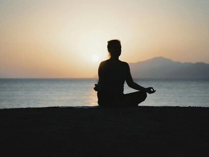 Mujer meditando junto al mar