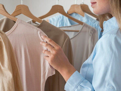 A woman exploring new eco-friendly clothing options, featuring sustainable fashion items made from organic cotton and recycled materials