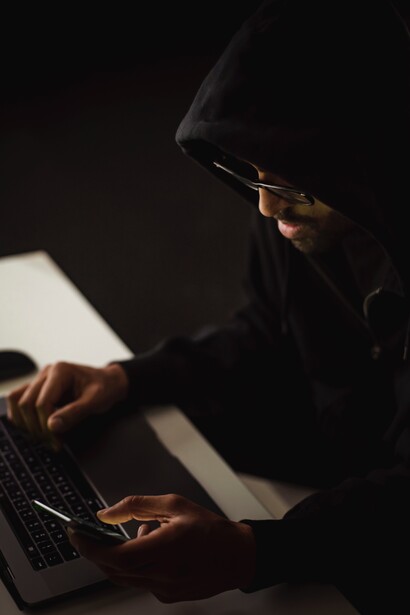 A person using a laptop and a phone to create an online income