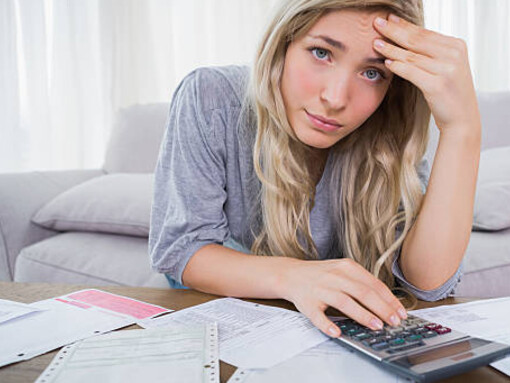 A thoughtful young woman grappling with financial stress caused by debt and high taxes