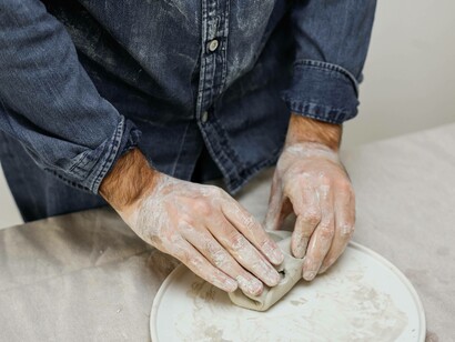 A man molding a piece of clay to what he believes fits him artistically