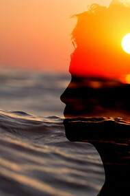 A captivating illustration showcasing the silhouette of a woman's head against the backdrop of a mesmerizing sunset