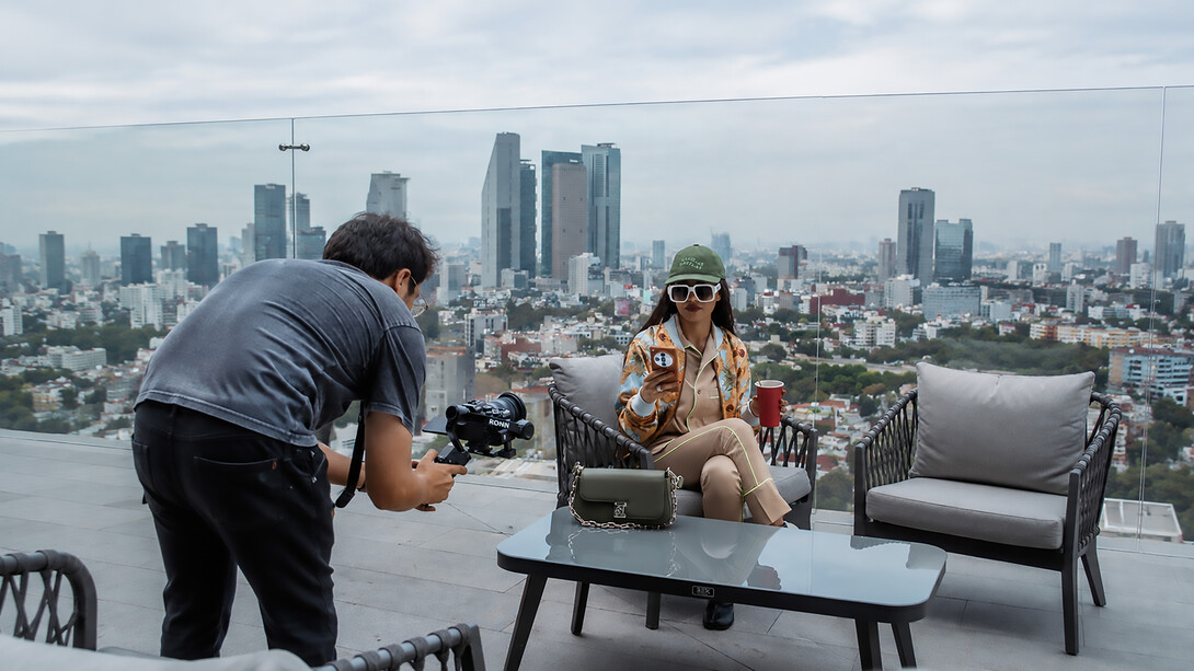 A fashion influencer is filmed on a rooftop terrace overlooking the skyline of Mexico City, Mexico