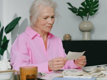 Mulher observa fotos antigas. Eu mesma tenho essa lembrança da minha avó, que jamais conheci. A imagem que tenho dela é de uma mulher doce, ereta, centrada, gentil e forte. Uma mulher que me inspira