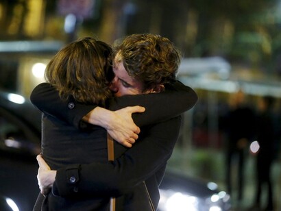 People hug near the Bataclan concert hall. Photograph: Christian Hartmann/Reuters