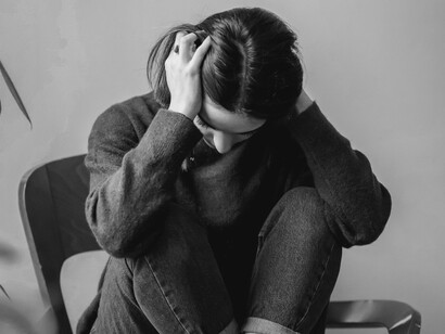 A woman with hands to her head coming to terms with her failure