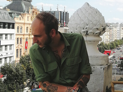 Anatol Svahilec overlooking Wenceslas square, his main Prague hood, and watching people from his balcony with the National Museum in the background, photo by Martina Kroa