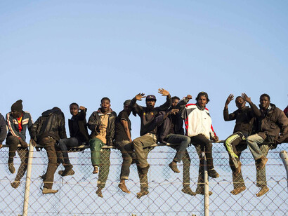 Inmigrantes encaramados a la valla de la frontera de Melilla