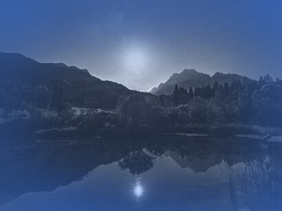 A bright lake with the full moon shining on the water