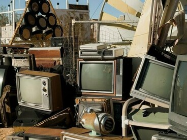 Stacks of ageing televisions and broken electronic equipment, symbolising the environmental burden created by discarded technology