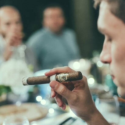 A well-lit table, fine cigars, and good company set the stage for an evening of camaraderie, where friendships are built over shared moments and the simple joy of slowing down to savor an experience
