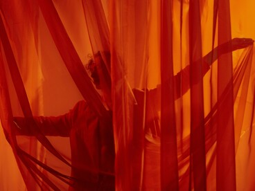 O bailarino surge entre as cortinas como quem atravessa uma fronteira entre presença e ausência. Assim também são os períodos de neblina da vida: nem sempre enxergamos o caminho, mas algo dentro de nós continua nos conduzindo. Nem toda transformação acontece à vista: algumas começam no silêncio, antes de se tornarem movimento