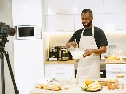 A male food influencer demonstrating how to use lettuce while recording a cooking video
