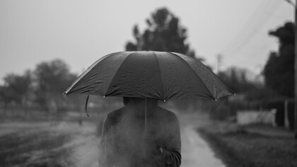 Homem anda sozinho pela chuva