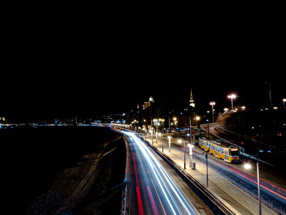 Cena noturna de pessoas dentro de carros, retratando a atmosfera urbana de Belo Horizonte, Minas Gerais, Brasil. Uma jornada emocional entre as luzes da cidade e as adversidades da vida