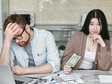 A man and woman budgeting together amid financial anxiety and economic stress